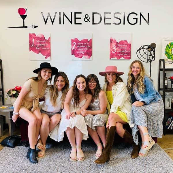 A group of people in front of the Wine and Design Logo